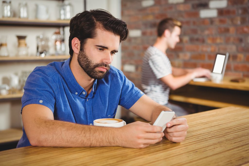 Young man using his tablet in cafe