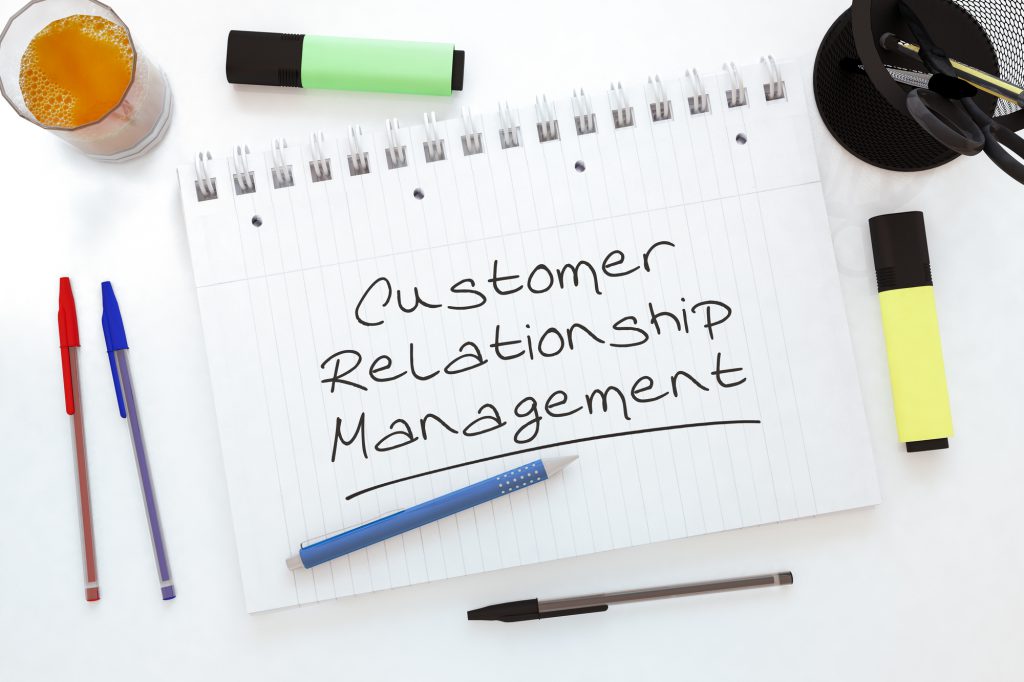 Customer Relationship Management - handwritten text in a notebook on a desk - 3d render illustration.